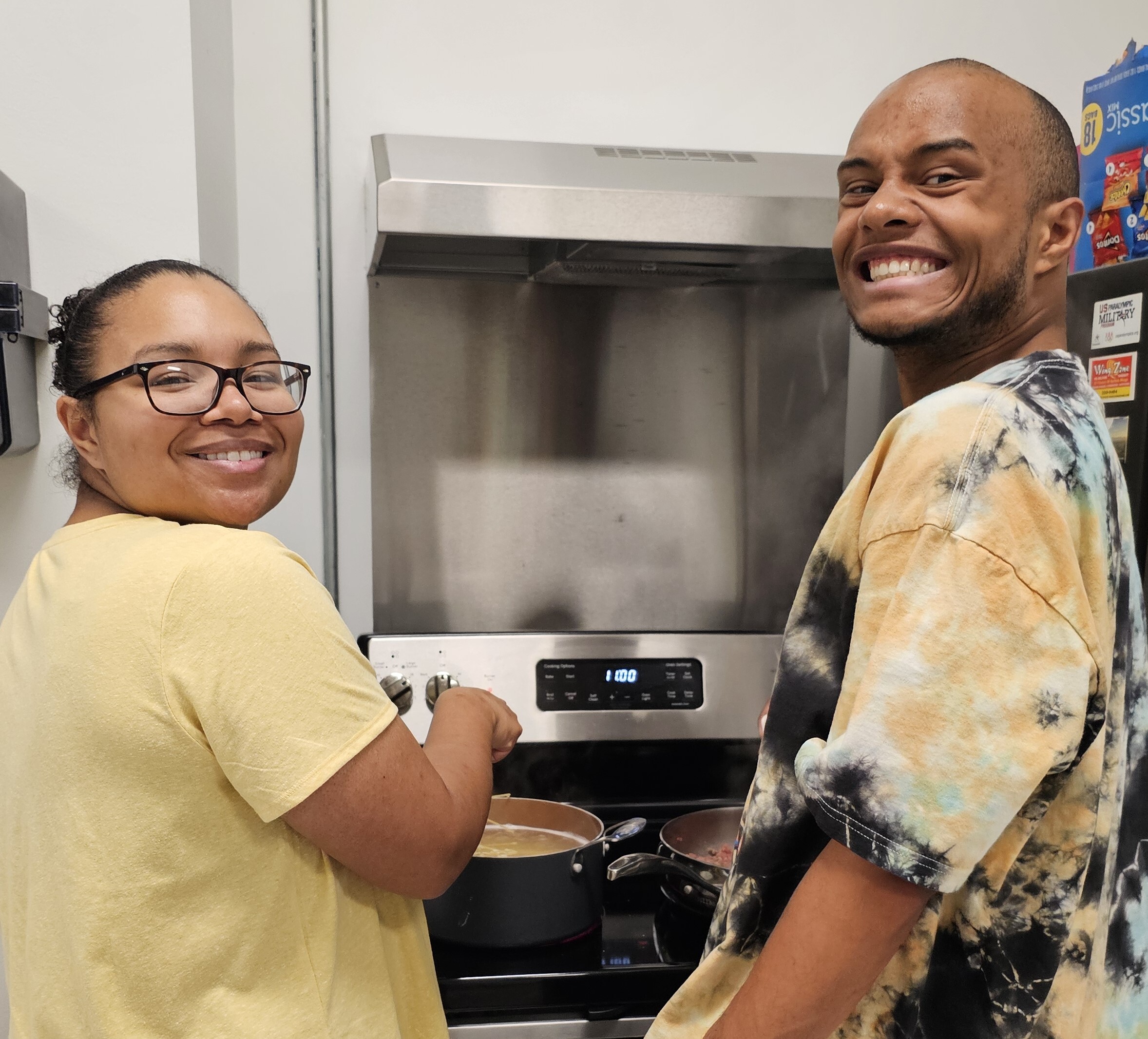 man and woman cooking and smiling